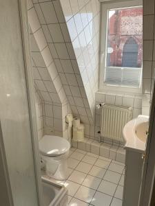 a white bathroom with a toilet and a sink at Marienkirche 2 - ABC336 in Wismar +14 photos