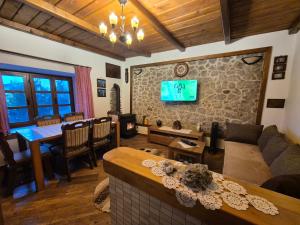 a living room with a couch and a tv on a wall at Apartments "Old house Mustafic" in Bar