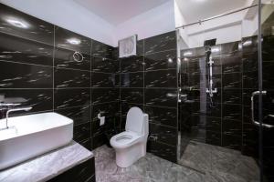 a black tiled bathroom with a toilet and a sink at Ollie resort in Ella +112 photos