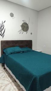 a bedroom with a bed with a green comforter at Casa Vivah in Lençóis
