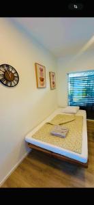 een slaapkamer met een bed en een klok aan de muur bij Villa Lakeview Appartment in Leissigen +7 foto's