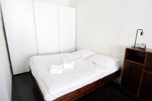 a bed in a room with white sheets and pillows at Zuhause am Boulevard - ABC40 in Wismar