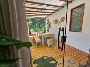 een kamer met een houten terras met een tafel bij Maison CATU in Itacaré