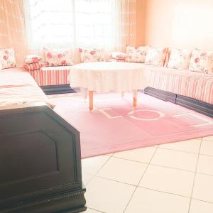a living room with a table and a couch at Miss ALIA Aéroport in Tangier