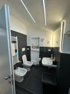 a bathroom with two sinks and two toilets in it at Silver Apartment Milano in Agrate Brianza