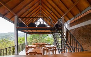 a staircase in a room with tables and chairs at Ollie resort in Ella