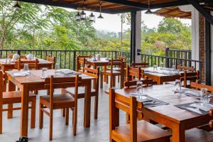 a restaurant with wooden tables and chairs on a balcony at Ollie resort in Ella