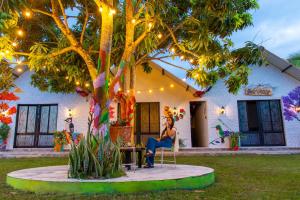 a woman sitting in a chair in front of a house at Cabañas Villa del Prado in Gigante