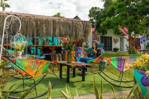 a woman sitting at a table in a garden at Cabañas Villa del Prado in Gigante