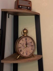 eine Uhr auf einem Regal mit einem Radio darauf in der Unterkunft Loft 84 in Piacenza