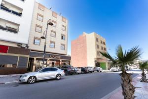 een rij auto's geparkeerd aan de kant van een straat bij 2 Voies Résidence in Dakhla