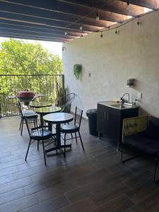 un patio con tavoli, sedie e lavandino di Casa del Olivo Suite 2 a Parras de la Fuente