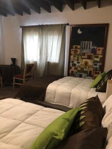 una camera da letto con due letti e una finestra di Casa del Olivo Suite 2 a Parras de la Fuente Altre 22 foto