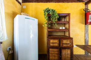 een witte koelkast naast een plank met een plant bij Casa Mangará Trancoso in Trancoso
