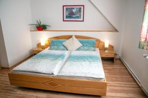 una camera con letto in legno e cuscini blu di Haus Prodinger a Weisspriach
