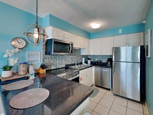 a kitchen with white cabinets and a stainless steel refrigerator at Perdido Skye #54 in Perdido Key +23 photos