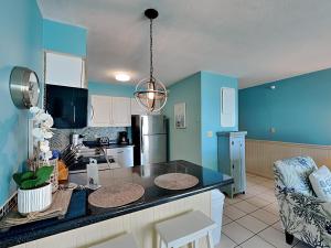 a kitchen with blue walls and a black counter top at Perdido Skye #54 in Perdido Key