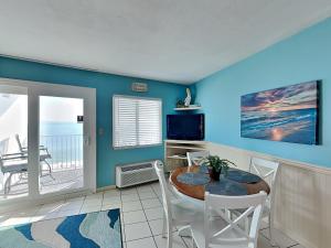 a dining room with a table and chairs and a television at Perdido Skye #54 in Perdido Key