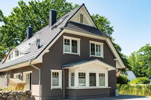 a black house with a gambrel roof at Darss Duett 2 in Prerow