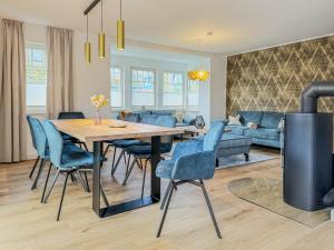 a dining room and living room with a table and blue chairs at Darss Duett 2 in Prerow