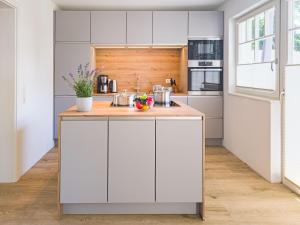 a kitchen with white cabinets and a wooden counter top at Darss Duett 2 in Prerow