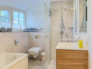 a bathroom with a shower and a toilet and a sink at Darss Duett 2 in Prerow +10 photos