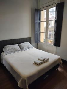 een slaapkamer met een bed met twee handdoeken erop bij Hostal Vampayá in Salta