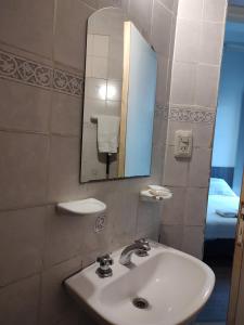 een badkamer met een wastafel en een spiegel bij Hostal Vampayá in Salta