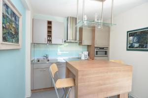 a kitchen with white cabinets and a wooden counter top at Ferienwohnung Malerwinkel in Seedorf