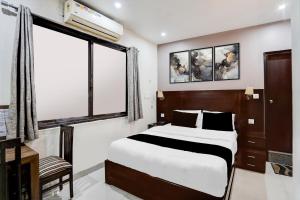 a bedroom with a large bed and a window at Super Collection O Prem Nagar Dehradun Formerly Hotel Parjaat Residency in Jhājra