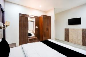een slaapkamer met een bed en een flatscreen-tv bij Collection O Prem Nagar Dehradun Formerly Hotel Parjaat Residency in Dehradun +40 foto's