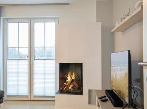 einen Kamin im Wohnzimmer mit Kamin in der Unterkunft Alte Fischfabrik Ruheinsel in Lauterbach