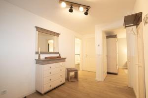 ein weißes Badezimmer mit Waschbecken und Spiegel in der Unterkunft Alte Fischfabrik Ruheinsel in Lauterbach