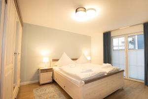 ein Schlafzimmer mit einem weißen Bett und einem Fenster in der Unterkunft Alte Fischfabrik Ruheinsel in Lauterbach + 9 Fotos