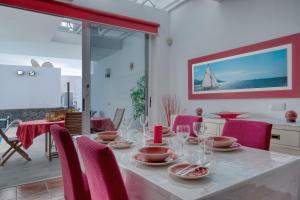 a dining room with a table with red chairs at Villa Mariña- Heated pool in Playa Blanca