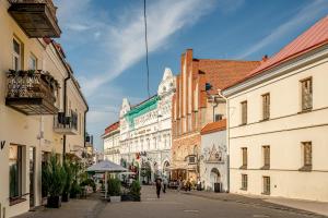 een straat met gebouwen en mensen die over straat lopen bij ROOMA Apartments in Vilnius