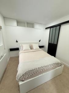 a white bedroom with a large white bed with pillows at Sublime logement neuf in Thaon-les-Vosges