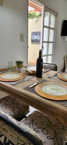 a table with plates and a bottle of wine on it at Temporario CNQ in Corrientes