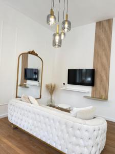 a white couch in a living room with a mirror at Sublime logement neuf in Thaon-les-Vosges