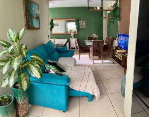 een woonkamer met een blauwe bank en een eetkamer bij Casa verde 4 quartos in Goiânia