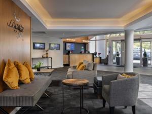 a lobby with couches and chairs and a counter at Mercure Queenstown Resort in Queenstown