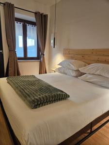 un grande letto con una coperta sopra di Dolcevita guest house a Torreano Altre 64 foto