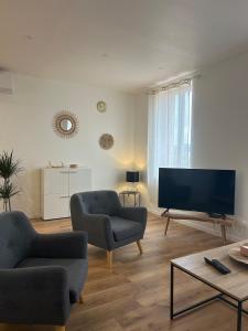 a living room with two chairs and a flat screen tv at Ranteil in Albi