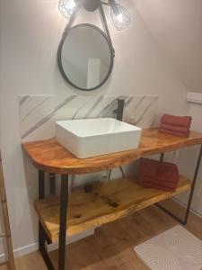 a white sink on a wooden table with a mirror at Ranteil in Albi +9 photos