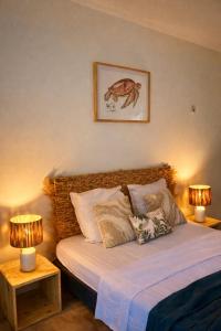 a bedroom with a bed with two lamps on tables at Résidence Yacinthe in Le Robert