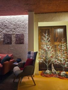 un soggiorno con un albero di Natale e una sedia di Dolcevita guest house a Torreano