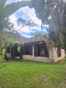 ein altes Backsteinhaus mit einem Rasenhof in der Unterkunft Casa rústica divertida in Florianópolis
