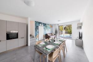 een keuken en eetkamer met een tafel en stoelen bij Villa Prestige in Sirmione