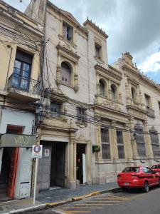 een rode auto geparkeerd voor een gebouw bij Hostal Vampayá in Salta +105 foto's