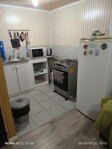 a small kitchen with a stove and a refrigerator at Casa en arriendo in Quintero
